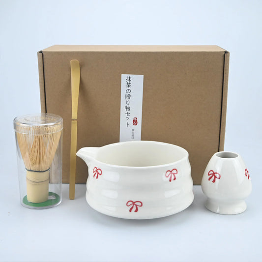 Matcha ceremony set with spouted ceramic bowl, bamboo whisk and red bow