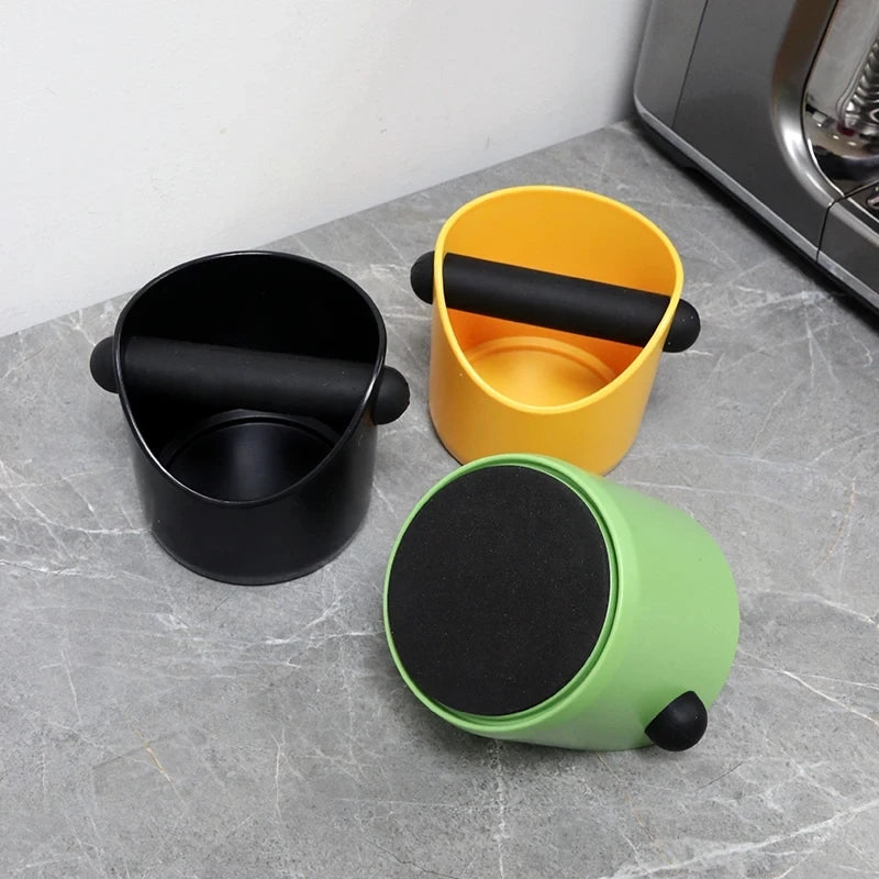 Espresso knock boxes on a kitchen worktop, one tipped over to show the non-slip base